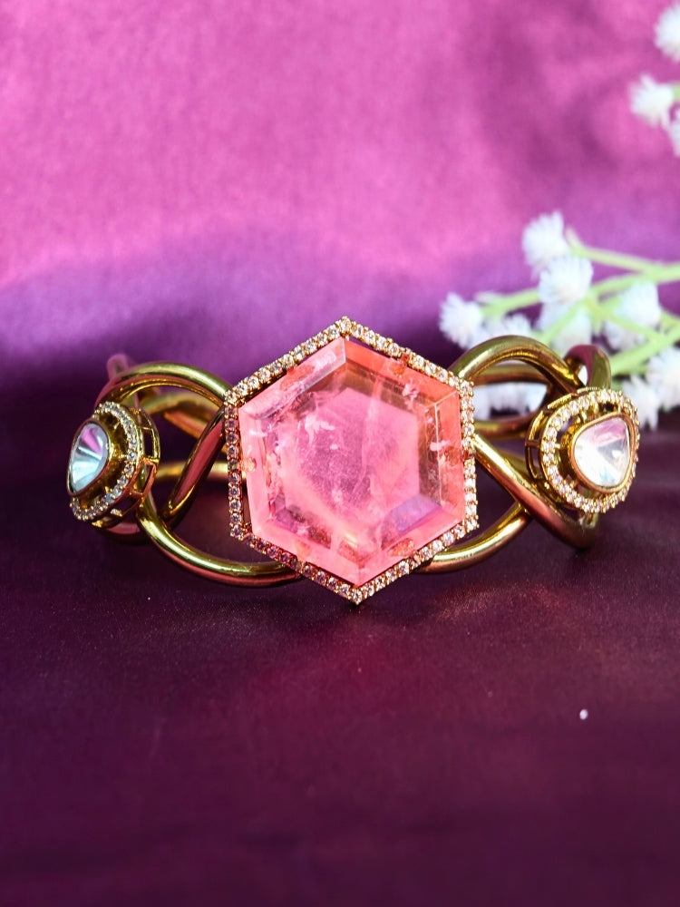 The Tahira Mint Pink Bracelet (Adjustable) features a large hexagonal Mint Pink stone at the center, with an american diamond border and two round kundan stones on each side, displayed on Purple satin fabric with white flowers in the background.