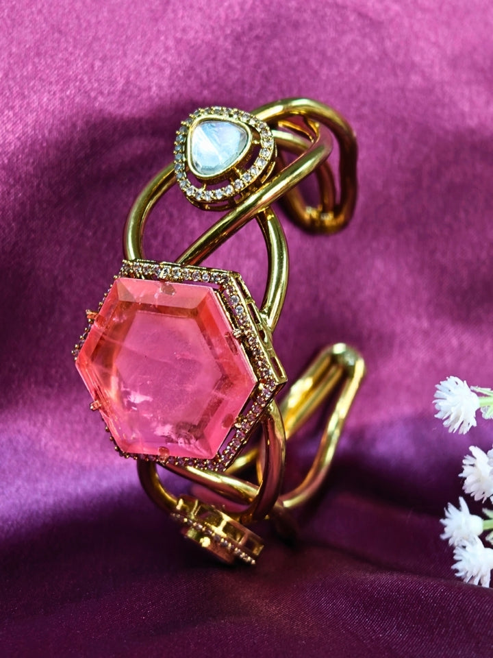 The Tahira Mint Pink Bracelet (Adjustable) features a large hexagonal Mint Pink stone at the center, with an american diamond border and two round kundan stones on each side, displayed on Purple satin fabric with white flowers in the background.