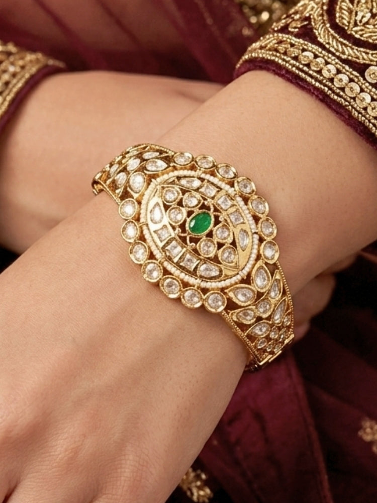 Close-up of a woman wearing an ornate traditional (Gold Polish) Green Bracelet with Polki, Green Colored Stone and Pearl. Wedding guest wearing a minimal artificial Polki bracelet. Close-up of a high-quality imitation Polki bracelet for festive wear.