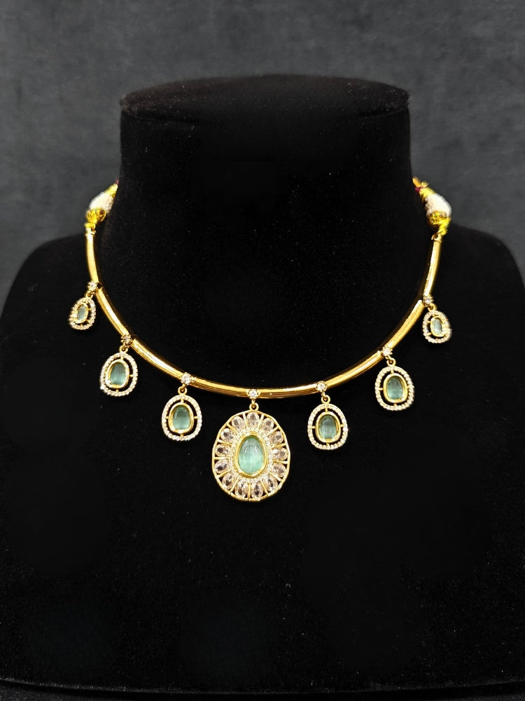 Close-up of an ornate Indo-western Mint Green (Dull gold) Hasli Diamond jewellery set and earrings with American Diamond and Colored Stones. Wedding guest wearing a sparkling American diamond necklace with a saree.
Close-up shot of a high-quality American diamond artificial necklace worn for festive celebrations.