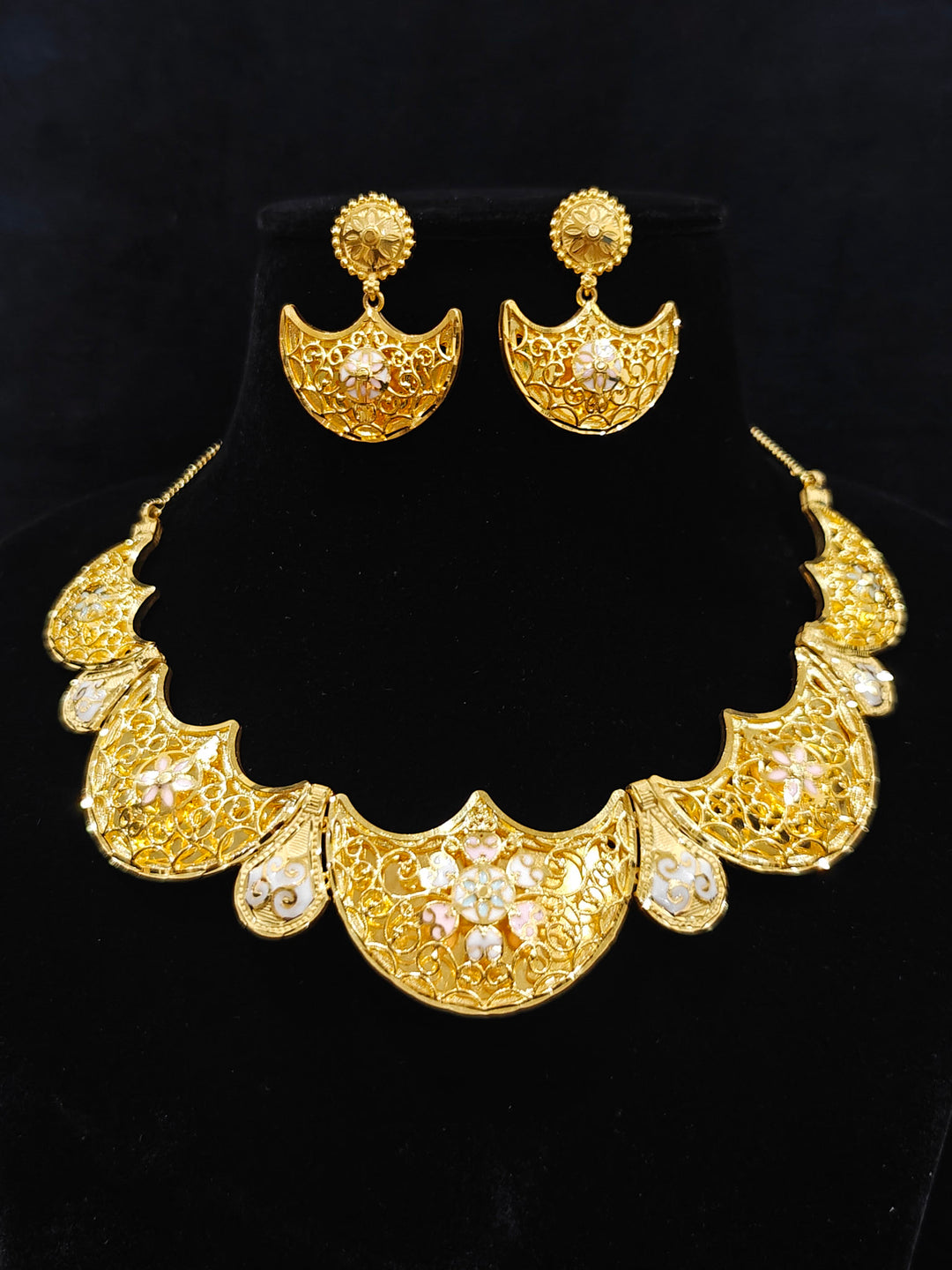 Close-up of an ornate traditional Meenakari gold Collar jewellery set and earrings with Filigree Work and Meenakari. Festive celebration look enhanced with traditional Meenakari jewelry. Close-up of detailed enamel craftsmanship in Meenakari jewelry.