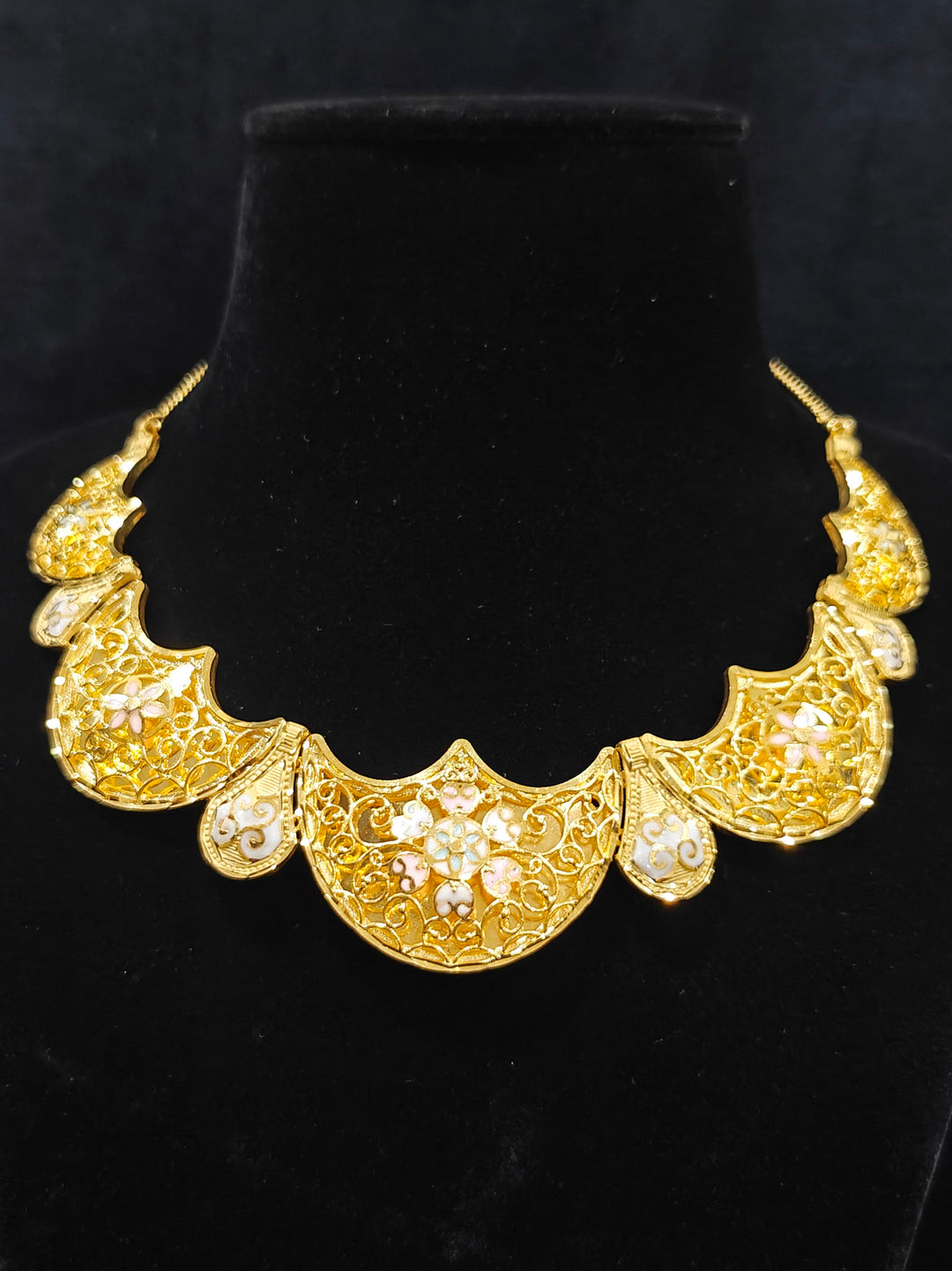 Close-up of an ornate traditional Meenakari gold Collar jewellery set and earrings with Filigree Work and Meenakari. Festive celebration look enhanced with traditional Meenakari jewelry. Close-up of detailed enamel craftsmanship in Meenakari jewelry.