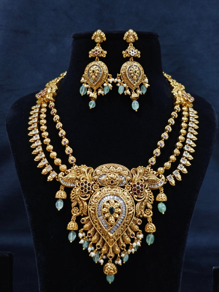 Close-up of an ornate traditional (Gold Polish) Collar jewellery set and earrings with American Diamond, Tumble Beads and Polki. Woman wearing a luxury artificial American Diamond jewelry set styled for an Indian wedding celebration. Traditional Indian bridal look featuring a premium imitation American Diamond jewelry set.