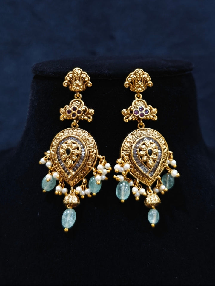 Close-up of an ornate traditional (Gold Polish) Collar jewellery set and earrings with American Diamond, Tumble Beads and Polki. Woman wearing a luxury artificial American Diamond jewelry set styled for an Indian wedding celebration. Traditional Indian bridal look featuring a premium imitation American Diamond jewelry set.