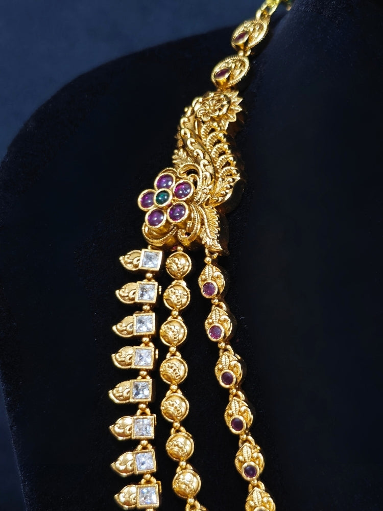 Close-up of an ornate traditional (Gold Polish) Collar jewellery set and earrings with American Diamond, Tumble Beads and Polki. Woman wearing a luxury artificial American Diamond jewelry set styled for an Indian wedding celebration. Traditional Indian bridal look featuring a premium imitation American Diamond jewelry set.