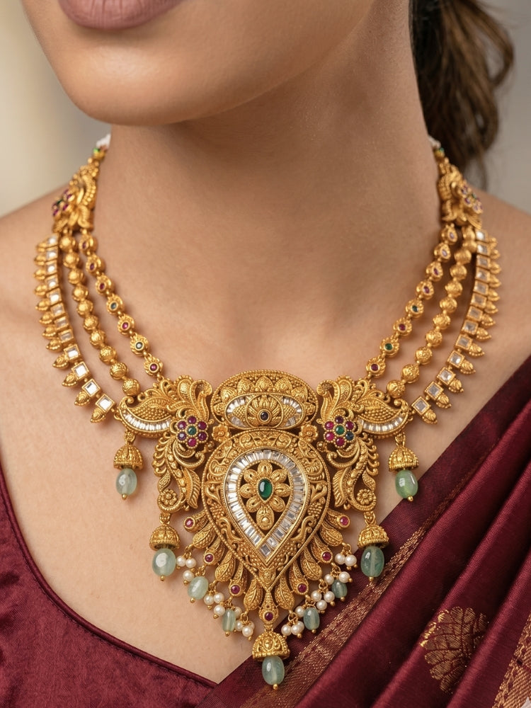 Close-up of a women wearing an ornate traditional (Gold Polish) Collar jewellery set and earrings with American Diamond, Tumble Beads and Polki. Woman wearing a luxury artificial American Diamond jewelry set styled for an Indian wedding celebration. Traditional Indian bridal look featuring a premium imitation American Diamond jewelry set.