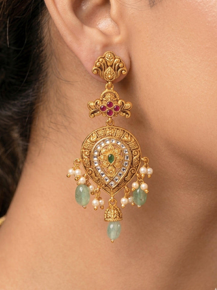 Close-up of a women wearing an ornate traditional (Gold Polish) Collar jewellery set and earrings with American Diamond, Tumble Beads and Polki. Woman wearing a luxury artificial American Diamond jewelry set styled for an Indian wedding celebration. Traditional Indian bridal look featuring a premium imitation American Diamond jewelry set.