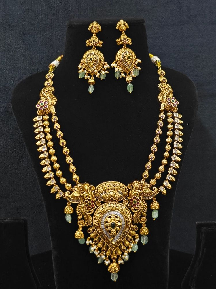 Close-up of an ornate traditional (Gold Polish) Collar jewellery set and earrings with American Diamond, Tumble Beads and Polki. Woman wearing a luxury artificial American Diamond jewelry set styled for an Indian wedding celebration. Traditional Indian bridal look featuring a premium imitation American Diamond jewelry set.