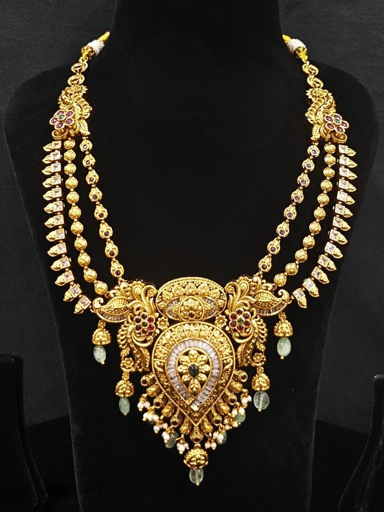 Close-up of an ornate traditional (Gold Polish) Collar jewellery set and earrings with American Diamond, Tumble Beads and Polki. Woman wearing a luxury artificial American Diamond jewelry set styled for an Indian wedding celebration. Traditional Indian bridal look featuring a premium imitation American Diamond jewelry set.