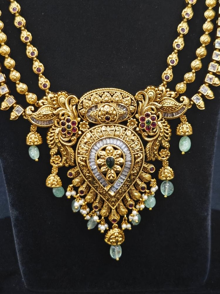 Close-up of an ornate traditional (Gold Polish) Collar jewellery set and earrings with American Diamond, Tumble Beads and Polki. Woman wearing a luxury artificial American Diamond jewelry set styled for an Indian wedding celebration. Traditional Indian bridal look featuring a premium imitation American Diamond jewelry set.