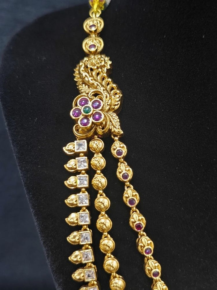 Close-up of an ornate traditional (Gold Polish) Collar jewellery set and earrings with American Diamond, Tumble Beads and Polki. Woman wearing a luxury artificial American Diamond jewelry set styled for an Indian wedding celebration. Traditional Indian bridal look featuring a premium imitation American Diamond jewelry set.