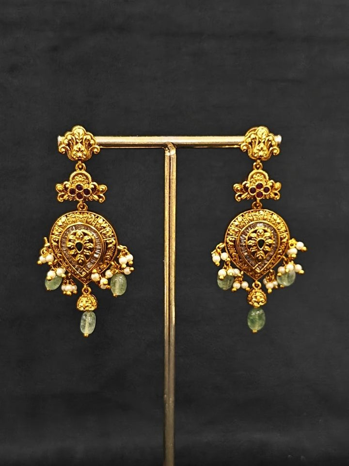 Close-up of an ornate traditional (Gold Polish) Collar jewellery set and earrings with American Diamond, Tumble Beads and Polki. Woman wearing a luxury artificial American Diamond jewelry set styled for an Indian wedding celebration. Traditional Indian bridal look featuring a premium imitation American Diamond jewelry set.