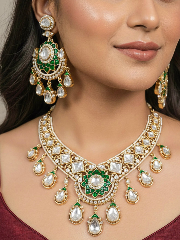 Close-up of a woman wearing an ornate traditional (Bright Gold) Green Collar jewellery set and earrings and maangtikka with Green Colored Stones, American Diamond, Pearls and Moissanite. Reception night styling featuring sparkling imitation Moissanite jewelry Set. Bride wearing a high-quality artificial Moissanite jewelry set for wedding rituals.