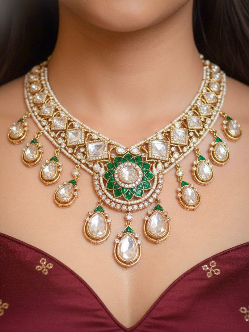 Close-up of a woman wearing an ornate traditional (Bright Gold) Green Collar jewellery set and earrings and maangtikka with Green Colored Stones, American Diamond, Pearls and Moissanite. Reception night styling featuring sparkling imitation Moissanite jewelry Set. Bride wearing a high-quality artificial Moissanite jewelry set for wedding rituals.