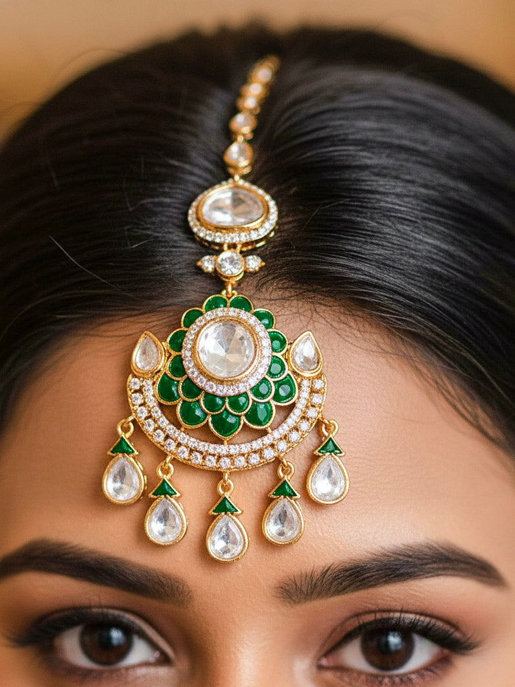Close-up of a woman wearing an ornate traditional (Bright Gold) Green Collar jewellery set and earrings and maangtikka with Green Colored Stones, American Diamond, Pearls and Moissanite. Reception night styling featuring sparkling imitation Moissanite jewelry Set. Bride wearing a high-quality artificial Moissanite jewelry set for wedding rituals.