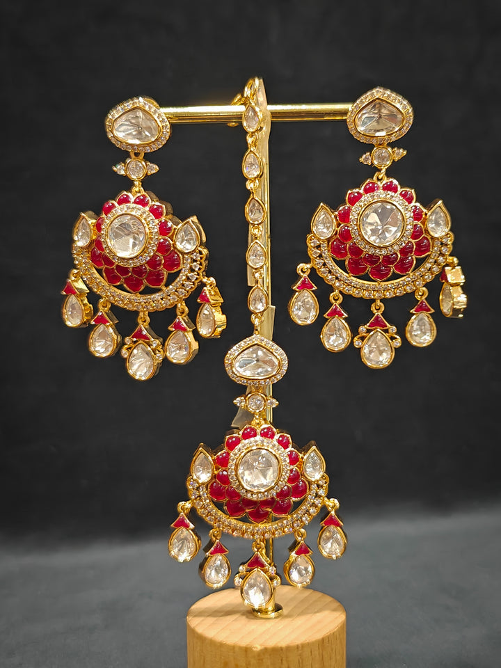 Close-up of an ornate traditional (Bright Gold) Red Collar jewellery set and earrings and maangtikka with Red Colored Stones, American Diamond, Pearls and Moissanite. Reception night styling featuring sparkling imitation Moissanite jewelry Set. Bride wearing a high-quality artificial Moissanite jewelry set for wedding rituals.