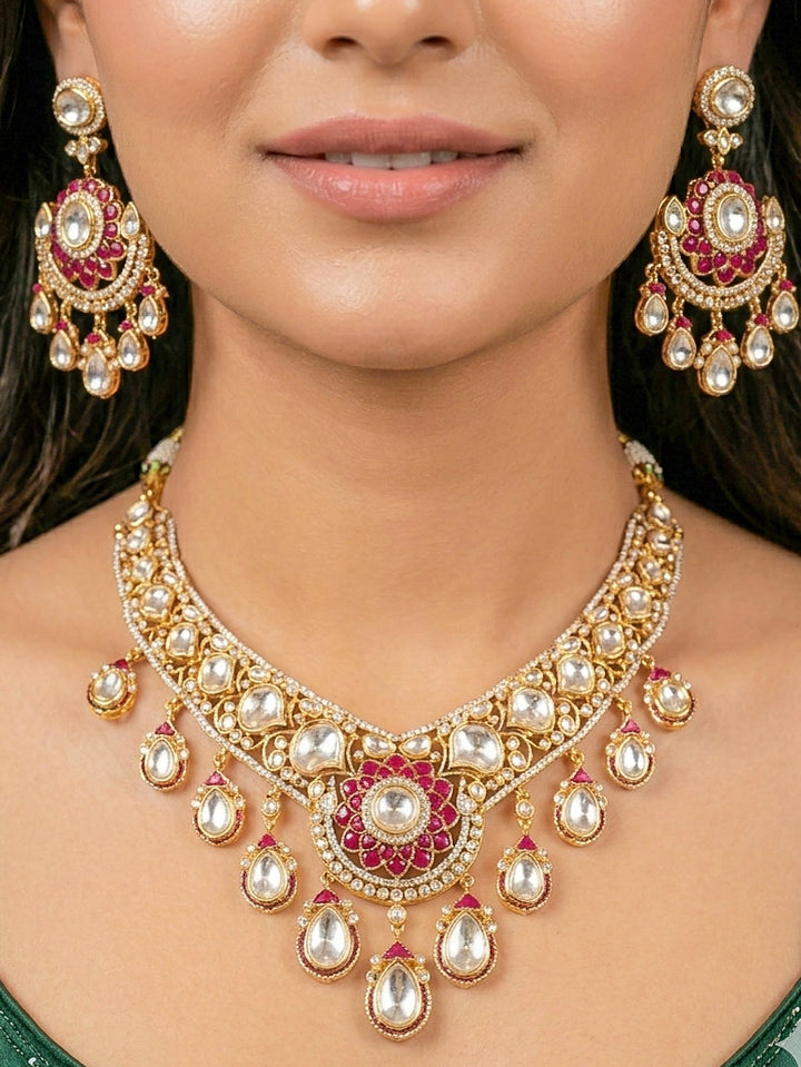 Close-up of a woman wearing an ornate traditional (Bright Gold) Red Collar jewellery set and earrings and maangtikka with Red Colored Stones, American Diamond, Pearls and Moissanite. Reception night styling featuring sparkling imitation Moissanite jewelry Set. Bride wearing a high-quality artificial Moissanite jewelry set for wedding rituals.