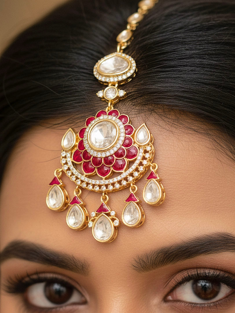 Close-up of a woman wearing an ornate traditional (Bright Gold) Red Collar jewellery set and earrings and maangtikka with Red Colored Stones, American Diamond, Pearls and Moissanite. Reception night styling featuring sparkling imitation Moissanite jewelry Set. Bride wearing a high-quality artificial Moissanite jewelry set for wedding rituals.