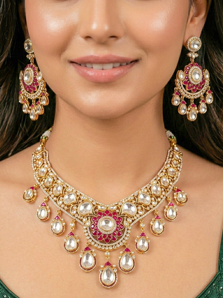 Close-up of a woman wearing an ornate traditional (Bright Gold) Red Collar jewellery set and earrings and maangtikka with Red Colored Stones, American Diamond, Pearls and Moissanite. Reception night styling featuring sparkling imitation Moissanite jewelry Set. Bride wearing a high-quality artificial Moissanite jewelry set for wedding rituals.