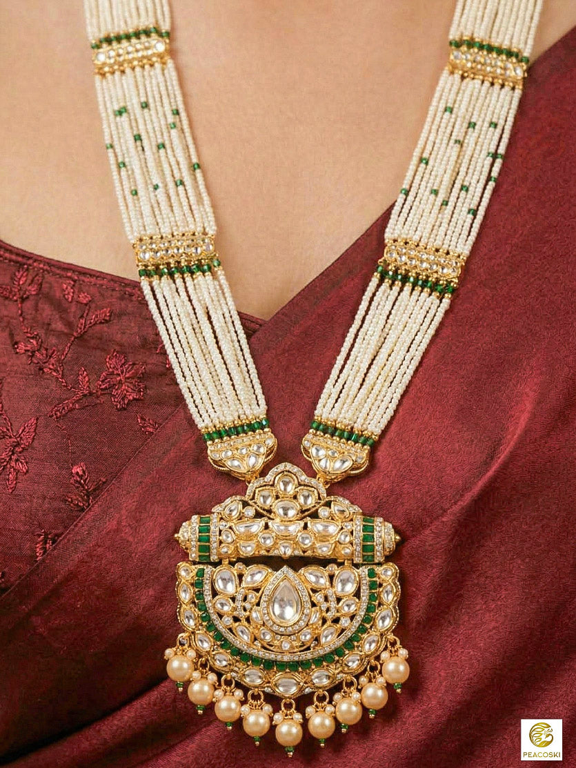 Close-up of a woman wearing an ornate traditional (Bright Gold) Green long jewellery set and earrings with Moissanite Polki, American Diamond, Green Colored Stones, Pearls, Beads and Hydro Crystals. Woman wearing Long artificial Moissanite jewelry for a grand celebration. Bride wearing a high-quality artificial Moissanite jewelry set for wedding rituals.