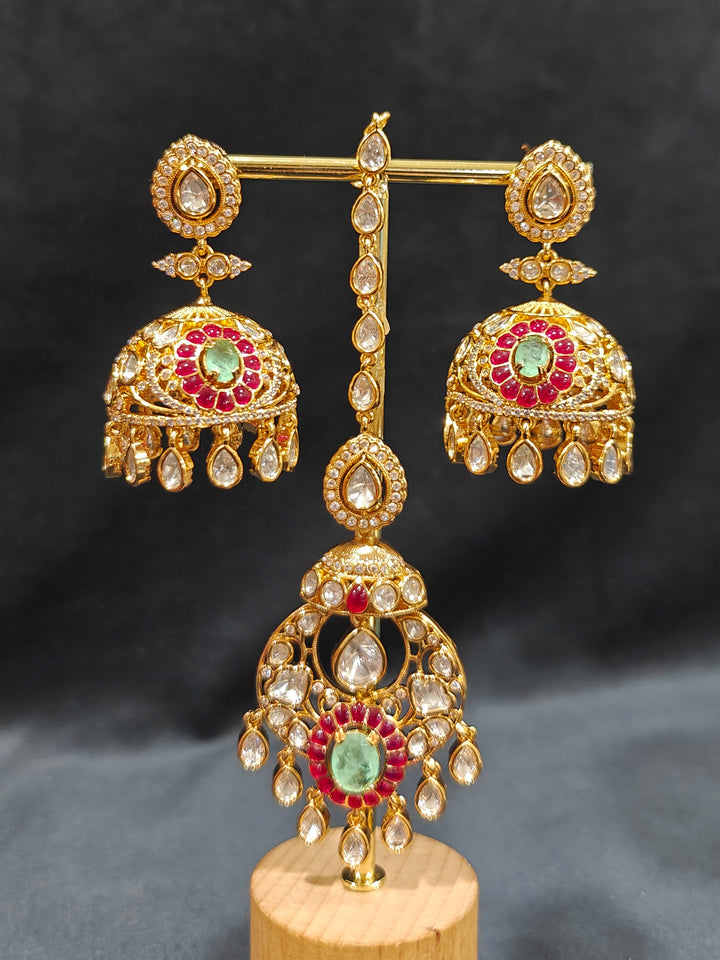 Close-up of an ornate traditional (Bright Gold) Mint Green and Ruby Pink Choker jewellery set and earrings and maangtikka with Doublet Stone, Moissanite, Kundan, American Diamond and Ruby Pink & Mint Green colored Stone. Bridal photoshoot look styled with a luxury imitation Moissanite jewelry set. Bride showcasing a traditional yet modern artificial Moissanite jewelry set design.