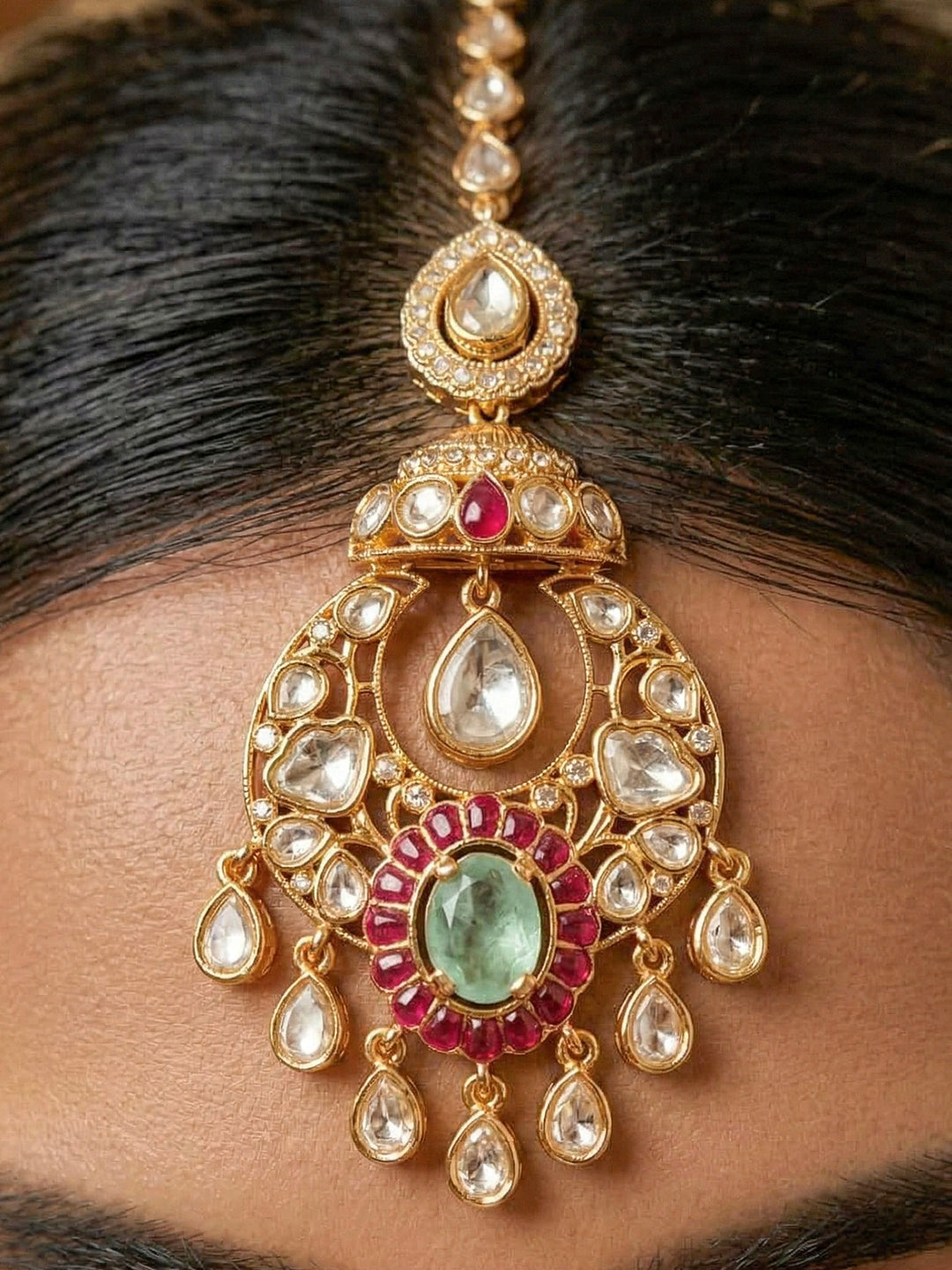 Close-up of a woman wearing an ornate traditional (Bright Gold) Mint Green and Ruby Pink Choker jewellery set and earrings and maangtikka with Doublet Stone, Moissanite, Kundan, American Diamond and Ruby Pink & Mint Green colored Stone. Bridal photoshoot look styled with a luxury imitation Moissanite jewelry set. Bride showcasing a traditional yet modern artificial Moissanite jewelry set design.