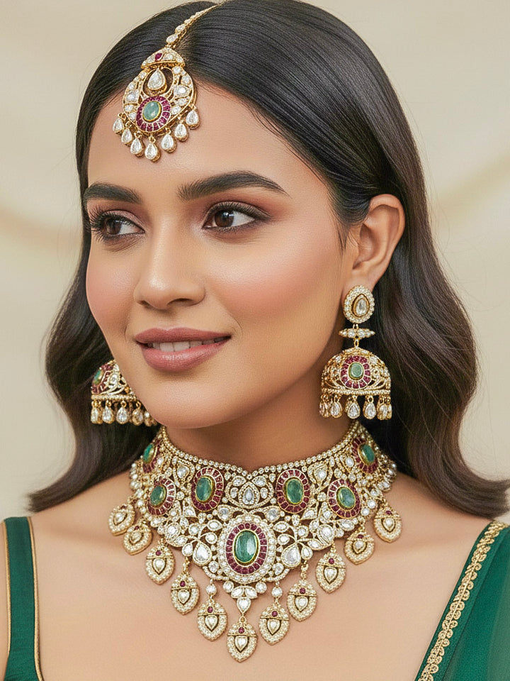 Close-up of a woman wearing an ornate traditional (Bright Gold) Mint Green and Ruby Pink Choker jewellery set and earrings and maangtikka with Doublet Stone, Moissanite, Kundan, American Diamond and Ruby Pink & Mint Green colored Stone. Bridal photoshoot look styled with a luxury imitation Moissanite jewelry set. Bride showcasing a traditional yet modern artificial Moissanite jewelry set design.