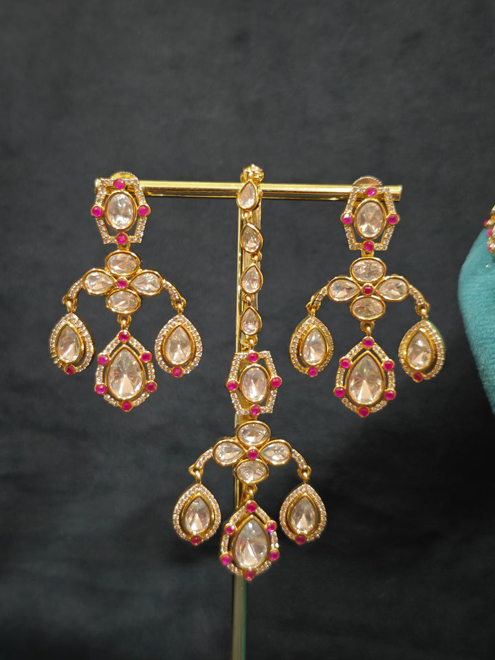 Close-up of an ornate traditional (Bright Gold) Pink Collar jewellery set and earrings and maangtikka with Kundan, Pink Colored Stones, American Diamond and Pearls. Bridal photoshoot look styled with a luxury imitation Moissanite jewelry set. Woman wearing Luxury artificial Moissanite jewelry for a grand celebration.