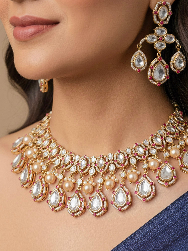 Close-up of a woman wearing an ornate traditional (Bright Gold) Pink Collar jewellery set and earrings and maangtikka with Kundan, Pink Colored Stones, American Diamond and Pearls. Bridal photoshoot look styled with a luxury imitation Moissanite jewelry set. Woman wearing Luxury artificial Moissanite jewelry for a grand celebration.