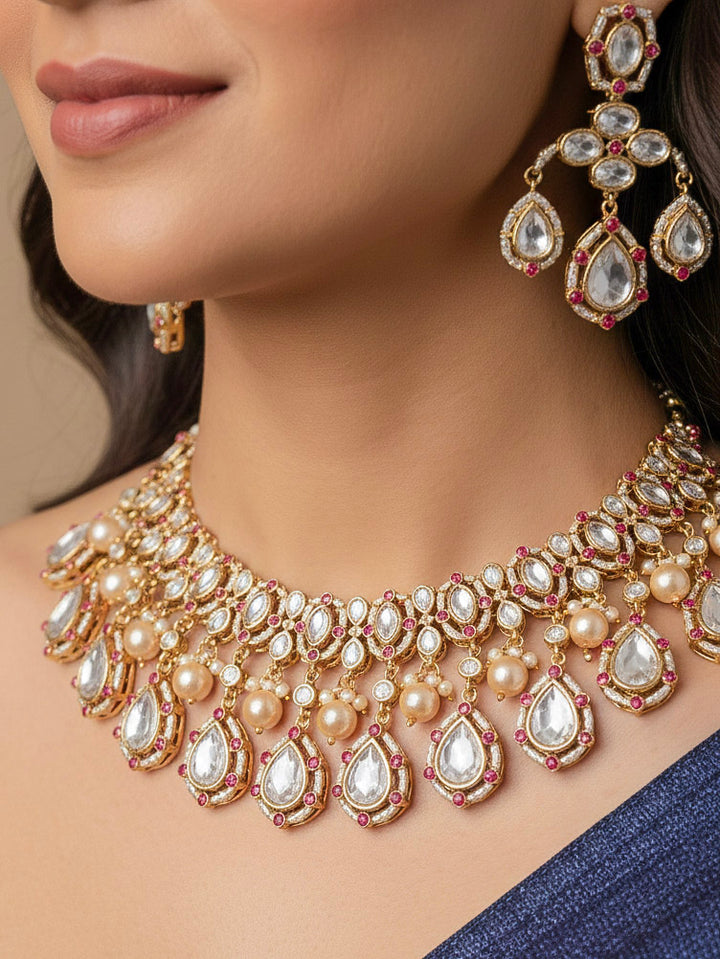 Close-up of a woman wearing an ornate traditional (Bright Gold) Pink Collar jewellery set and earrings and maangtikka with Kundan, Pink Colored Stones, American Diamond and Pearls. Bridal photoshoot look styled with a luxury imitation Moissanite jewelry set. Woman wearing Luxury artificial Moissanite jewelry for a grand celebration.