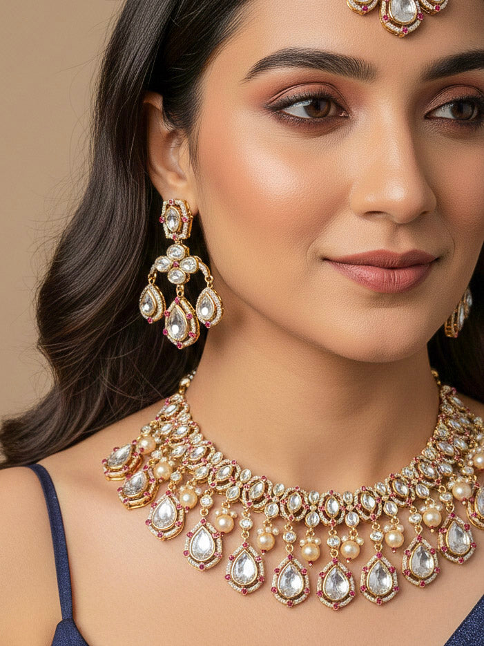 Close-up of a woman wearing an ornate traditional (Bright Gold) Pink Collar jewellery set and earrings and maangtikka with Kundan, Pink Colored Stones, American Diamond and Pearls. Bridal photoshoot look styled with a luxury imitation Moissanite jewelry set. Woman wearing Luxury artificial Moissanite jewelry for a grand celebration.
