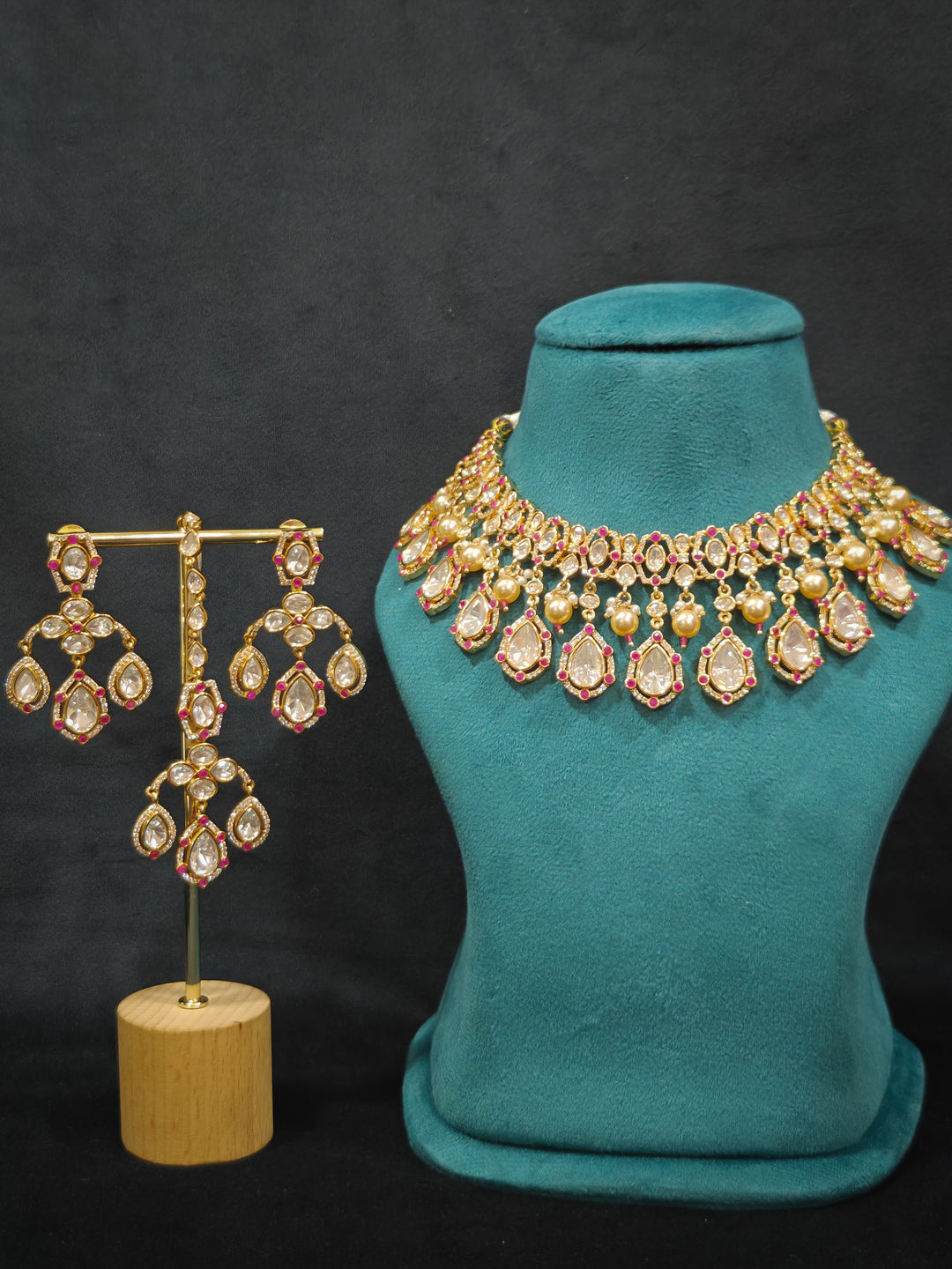 Close-up of an ornate traditional (Bright Gold) Pink Collar jewellery set and earrings and maangtikka with Kundan, Pink Colored Stones, American Diamond and Pearls. Bridal photoshoot look styled with a luxury imitation Moissanite jewelry set. Woman wearing Luxury artificial Moissanite jewelry for a grand celebration.