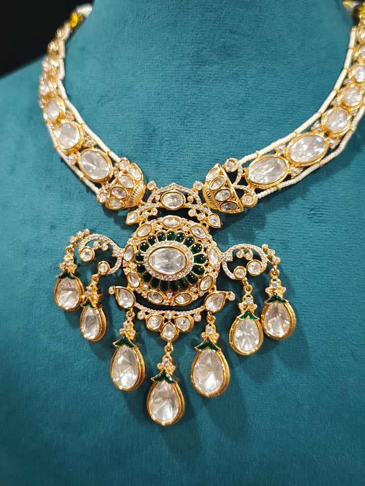 Close-up of an ornate traditional (Bright Gold) Green Collar jewellery set and earrings and maangtikka with Green Colored Stones, Kundan, American Diamond and Pearls. Woman wearing trending artificial Moissanite jewelry for wedding season in India. Bride wearing a high-quality artificial Moissanite jewelry set for wedding rituals.