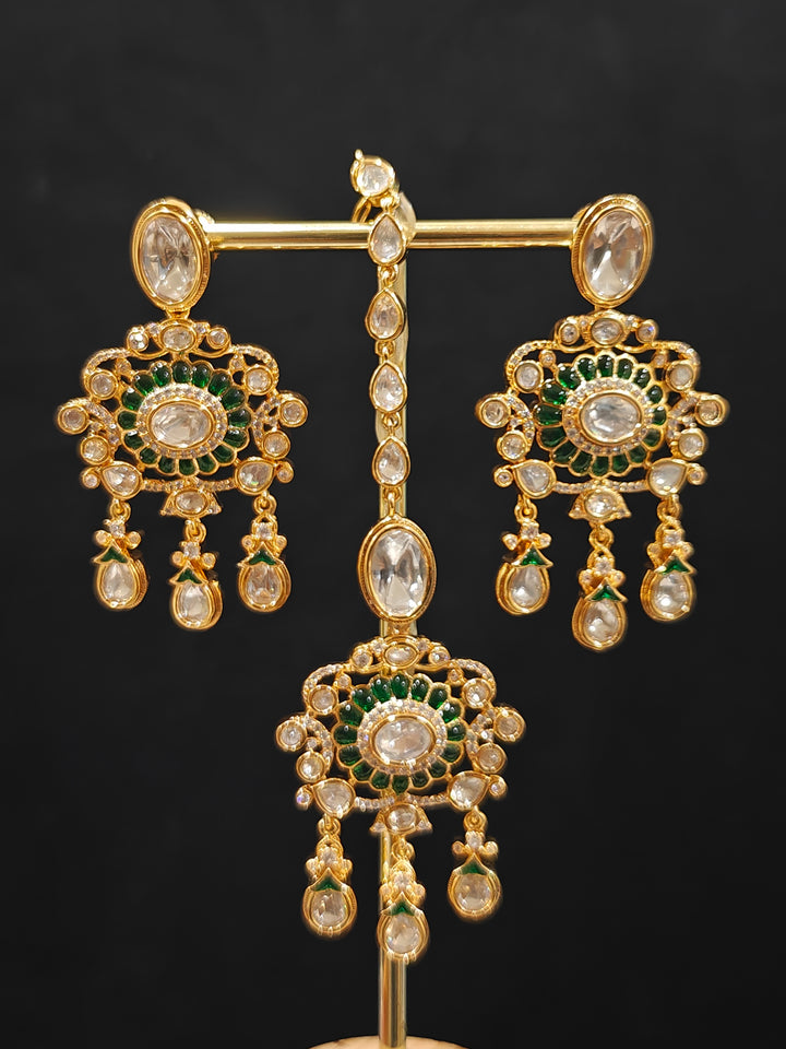 Close-up of an ornate traditional (Bright Gold) Green Collar jewellery set and earrings and maangtikka with Green Colored Stones, Kundan, American Diamond and Pearls. Woman wearing trending artificial Moissanite jewelry for wedding season in India. Bride wearing a high-quality artificial Moissanite jewelry set for wedding rituals.