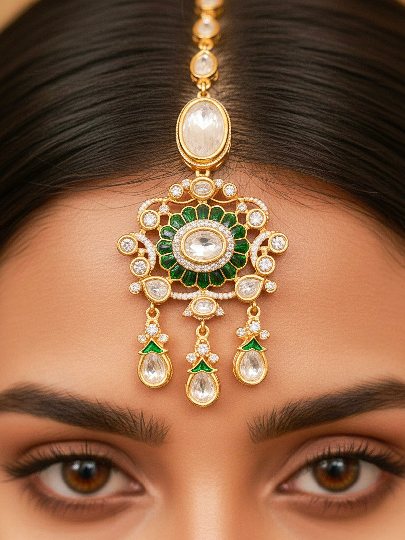 Close-up of a woman wearing an ornate traditional (Bright Gold) Green Collar jewellery set and earrings and maangtikka with Green Colored Stones, Kundan, American Diamond and Pearls. Woman wearing trending artificial Moissanite jewelry for wedding season in India. Bride wearing a high-quality artificial Moissanite jewelry set for wedding rituals.