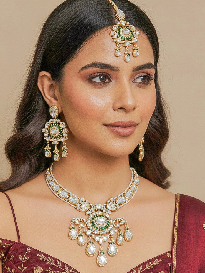 Close-up of a woman wearing an ornate traditional (Bright Gold) Green Collar jewellery set and earrings and maangtikka with Green Colored Stones, Kundan, American Diamond and Pearls. Woman wearing trending artificial Moissanite jewelry for wedding season in India. Bride wearing a high-quality artificial Moissanite jewelry set for wedding rituals.