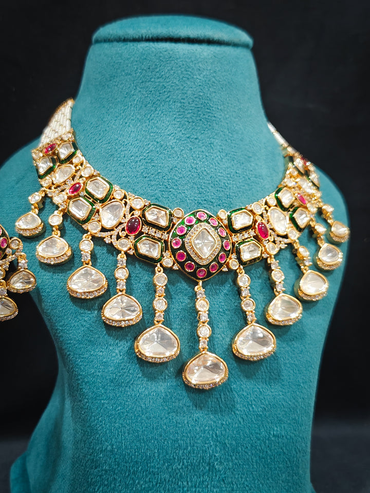 Close-up of an ornate traditional Meenakari Green and Pink Collar jewellery set and earrings and maangtikka with Pink Colored Stones, Uncut Kundan, American Diamond and Meenakari. Close-up of intricate Meenakari detailing in imitation bridal jewelry. Royal Indian bridal styling featuring a handcrafted Meenakari set.