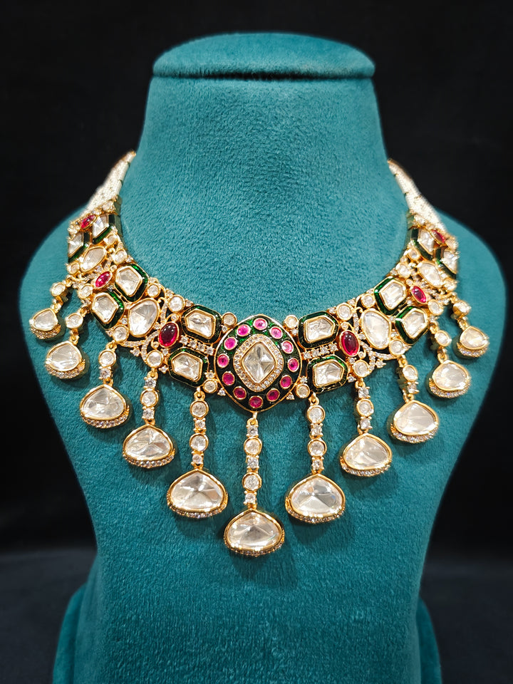 Close-up of an ornate traditional Meenakari Green and Pink Collar jewellery set and earrings and maangtikka with Pink Colored Stones, Uncut Kundan, American Diamond and Meenakari. Close-up of intricate Meenakari detailing in imitation bridal jewelry. Royal Indian bridal styling featuring a handcrafted Meenakari set.