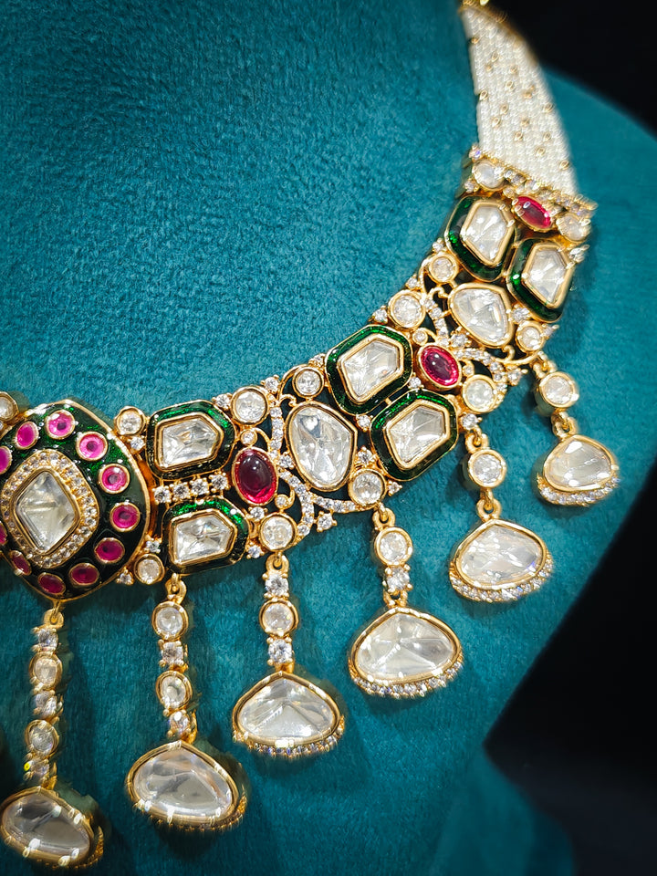 Close-up of an ornate traditional Meenakari Green and Pink Collar jewellery set and earrings and maangtikka with Pink Colored Stones, Uncut Kundan, American Diamond and Meenakari. Close-up of intricate Meenakari detailing in imitation bridal jewelry. Royal Indian bridal styling featuring a handcrafted Meenakari set.