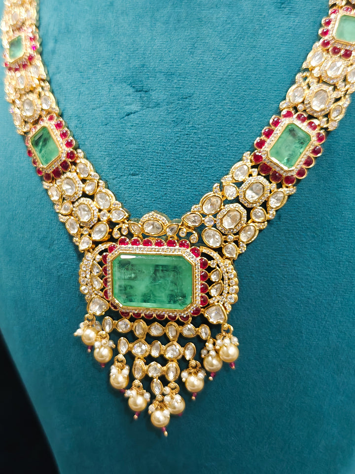 Close-up of an ornate traditional (Bright Gold) Mint Green and Ruby Pink jewellery set and earrings and maangtikka with American Diamond, Pink Colored Stones, Uncut Kundan, Pearls and Doublet Stone. Bride showcasing a premium imitation Moissanite  jewelry set for her reception look. Elegant Indian wedding look completed with luxury artificial  moissanite jewelry set. 