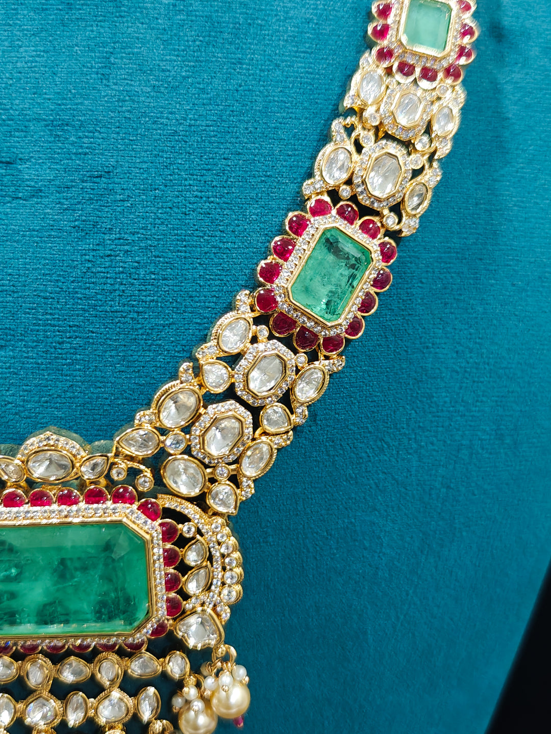 Close-up of an ornate traditional (Bright Gold) Mint Green and Ruby Pink jewellery set and earrings and maangtikka with American Diamond, Pink Colored Stones, Uncut Kundan, Pearls and Doublet Stone. Bride showcasing a premium imitation Moissanite  jewelry set for her reception look. Elegant Indian wedding look completed with luxury artificial  moissanite jewelry set. 
