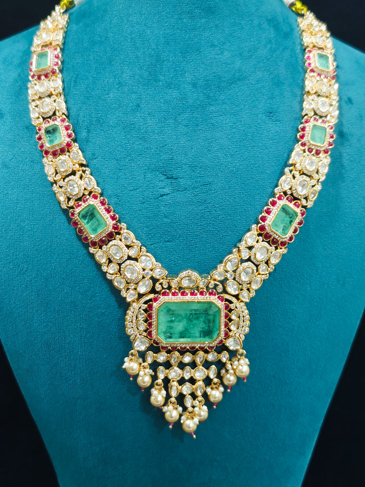 Close-up of an ornate traditional (Bright Gold) Mint Green and Ruby Pink jewellery set and earrings and maangtikka with American Diamond, Pink Colored Stones, Uncut Kundan, Pearls and Doublet Stone. Bride showcasing a premium imitation Moissanite  jewelry set for her reception look. Elegant Indian wedding look completed with luxury artificial  moissanite jewelry set. 