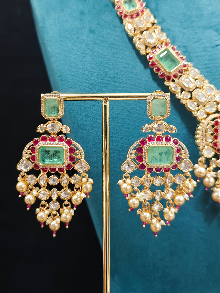Close-up of an ornate traditional (Bright Gold) Mint Green and Ruby Pink jewellery set and earrings and maangtikka with American Diamond, Pink Colored Stones, Uncut Kundan, Pearls and Doublet Stone. Bride showcasing a premium imitation Moissanite  jewelry set for her reception look. Elegant Indian wedding look completed with luxury artificial  moissanite jewelry set. 