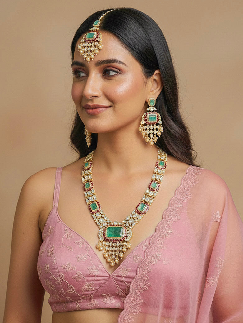 Close-up of a woman wearing an ornate traditional (Bright Gold) Mint Green and Ruby Pink jewellery set and earrings and maangtikka with American Diamond, Pink Colored Stones, Uncut Kundan, Pearls and Doublet Stone. Bride showcasing a premium imitation Moissanite  jewelry set for her reception look. Elegant Indian wedding look completed with luxury artificial  moissanite jewelry set. 