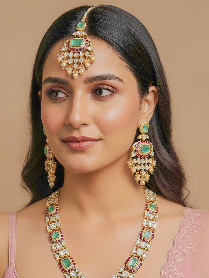 Close-up of a woman wearing an ornate traditional (Bright Gold) Mint Green and Ruby Pink jewellery set and earrings and maangtikka with American Diamond, Pink Colored Stones, Uncut Kundan, Pearls and Doublet Stone. Bride showcasing a premium imitation Moissanite  jewelry set for her reception look. Elegant Indian wedding look completed with luxury artificial  moissanite jewelry set. 