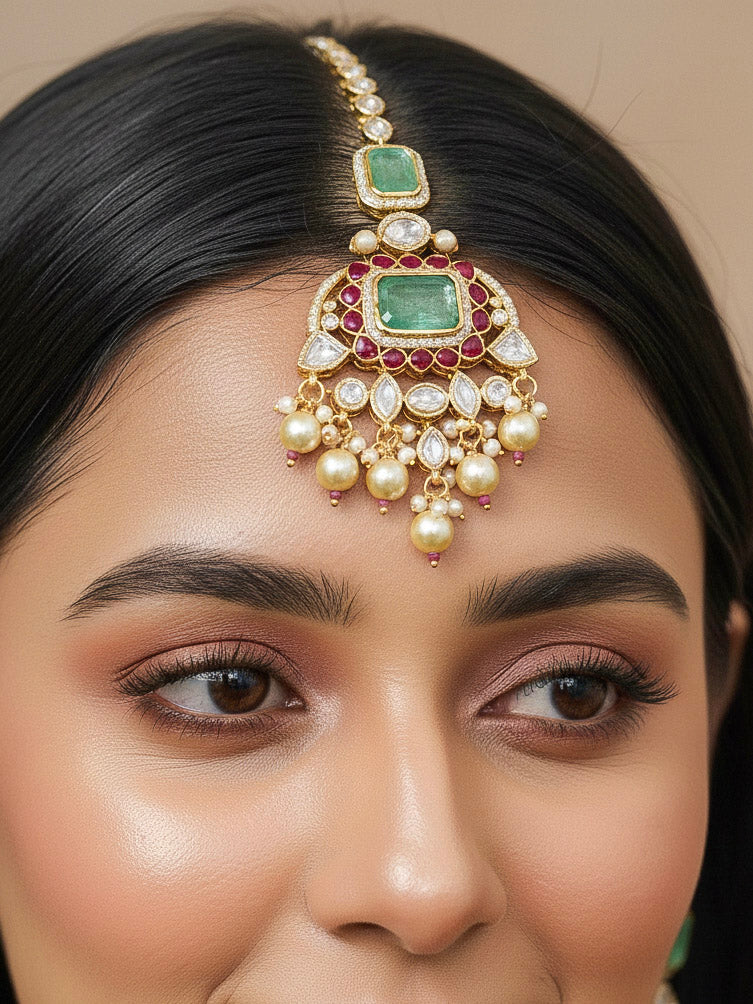 Close-up of a woman wearing an ornate traditional (Bright Gold) Mint Green and Ruby Pink jewellery set and earrings and maangtikka with American Diamond, Pink Colored Stones, Uncut Kundan, Pearls and Doublet Stone. Bride showcasing a premium imitation Moissanite  jewelry set for her reception look. Elegant Indian wedding look completed with luxury artificial  moissanite jewelry set. 