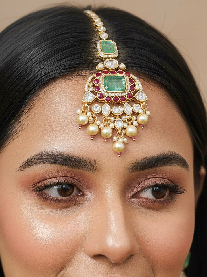 Close-up of a woman wearing an ornate traditional (Bright Gold) Mint Green and Ruby Pink jewellery set and earrings and maangtikka with American Diamond, Pink Colored Stones, Uncut Kundan, Pearls and Doublet Stone. Bride showcasing a premium imitation Moissanite  jewelry set for her reception look. Elegant Indian wedding look completed with luxury artificial  moissanite jewelry set. 