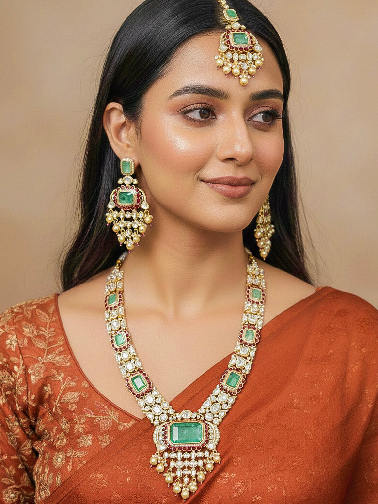 Close-up of a woman wearing an ornate traditional (Bright Gold) Mint Green and Ruby Pink jewellery set and earrings and maangtikka with American Diamond, Pink Colored Stones, Uncut Kundan, Pearls and Doublet Stone. Bride showcasing a premium imitation Moissanite  jewelry set for her reception look. Elegant Indian wedding look completed with luxury artificial  moissanite jewelry set. 