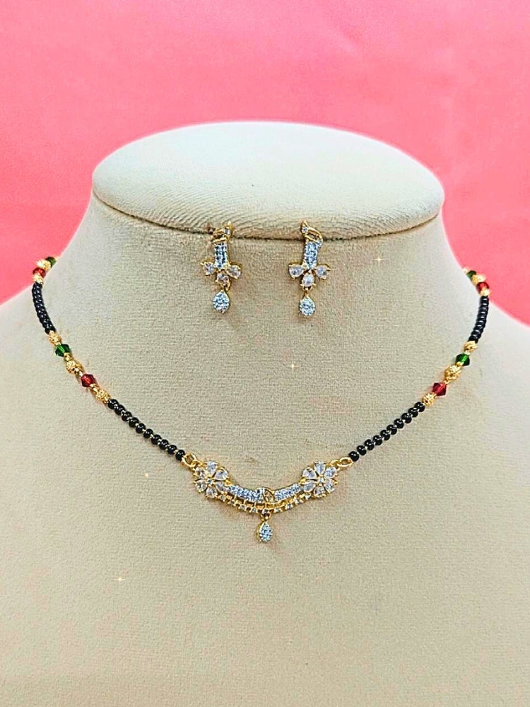 Tina Mangalsutra—a gold necklace with black mangalsutra beads and matching earrings, pendant featuring sparkling American Diamonds—set against a cream dummy, perfect for your wedding ceremony dress. Diamond mangalsutra. Modern mangalsutra. 