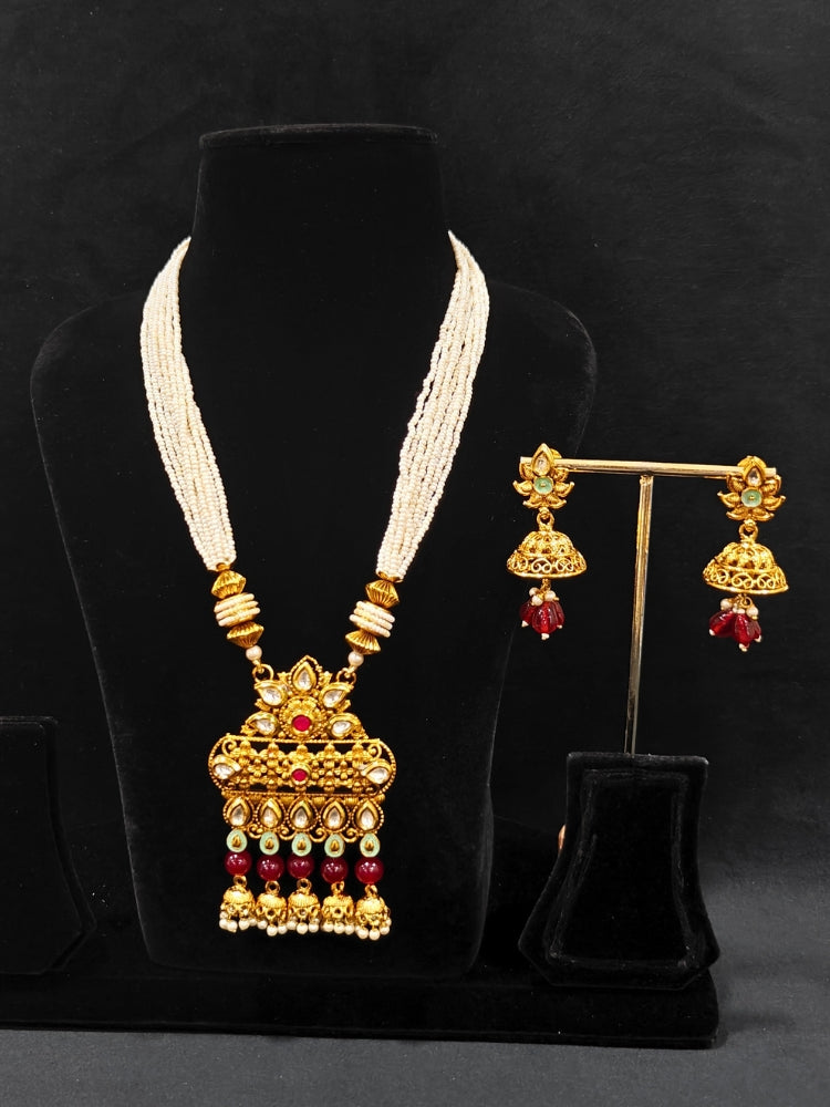 Close-up of an ornate traditional Rajwadi gold Long jewellery set and earrings with Kundan, Coloured Beads and pearls. Wedding guest styling a Rajwadi artificial necklace with a Saree. Festive look completed with a luxury Rajwadi imitation necklace.